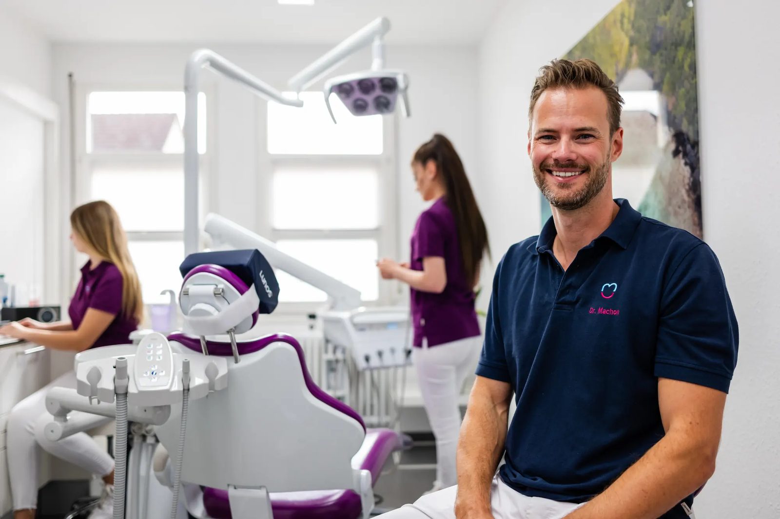 Dr. Sebastian Machon in seiner Zahnarztpraxis in Nürtingen, im Hintergrund arbeitet sein Team