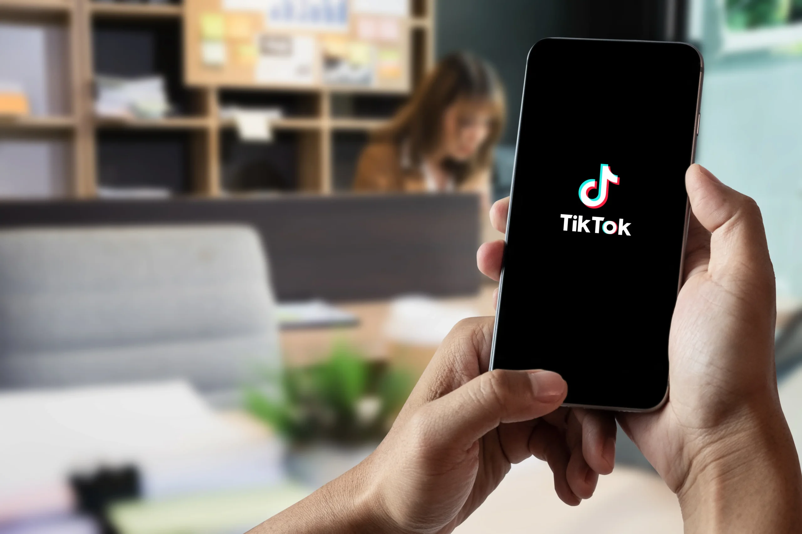 Handy mit TikTok Logo in Menschenhand